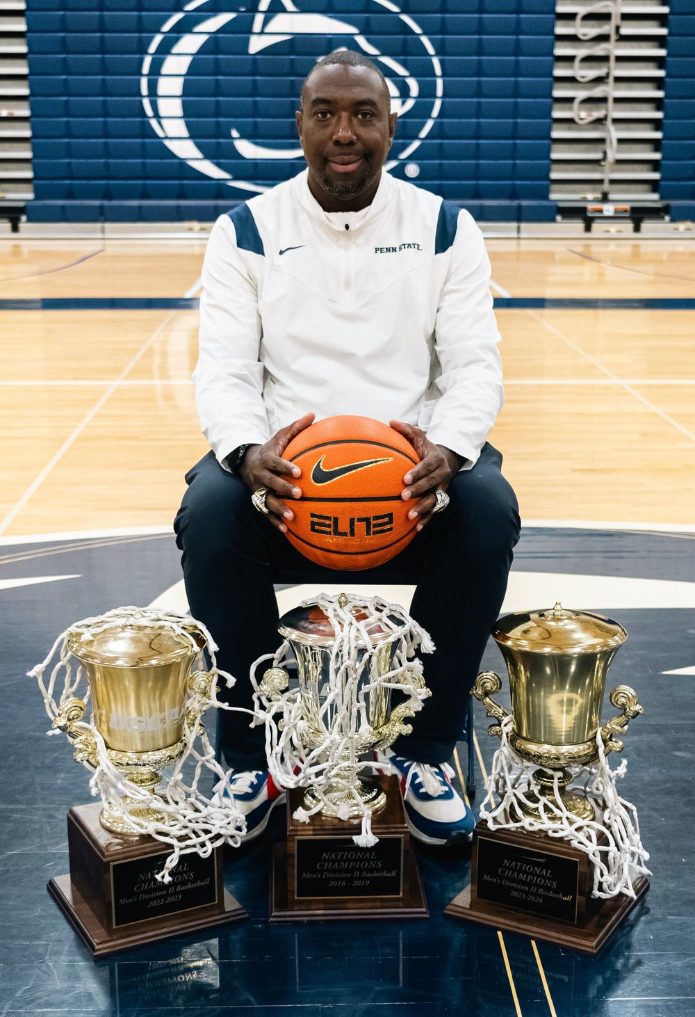Coach LeShawn R. Hammett with three national championship trophies